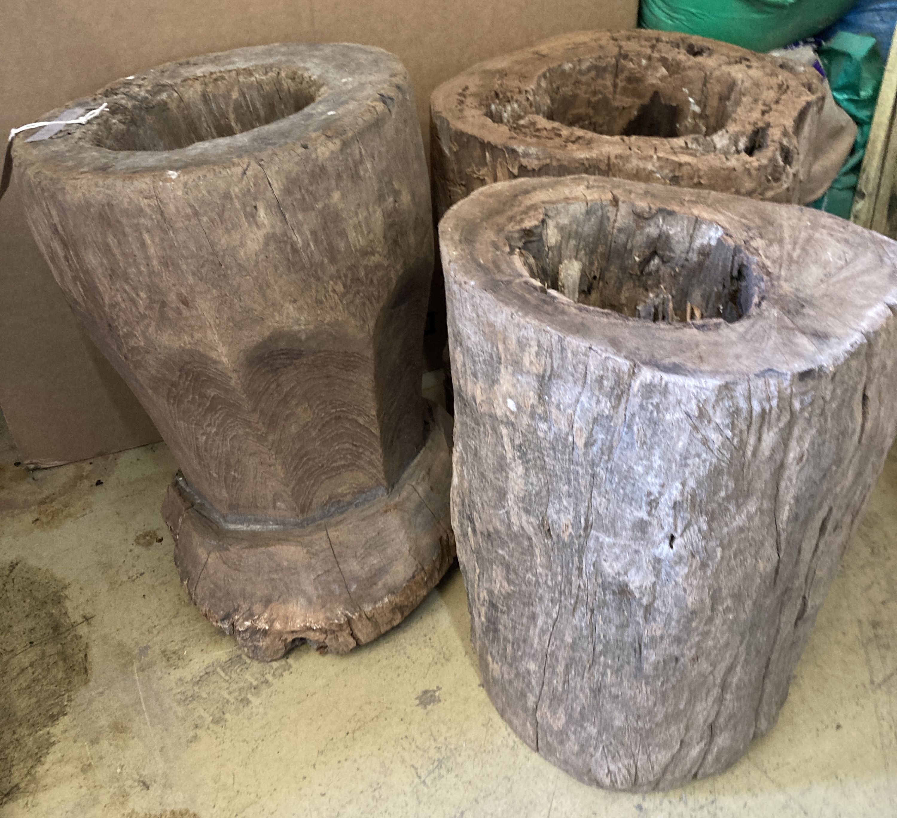 Three Indonesian hardwood rice mortars, largest 52cm high